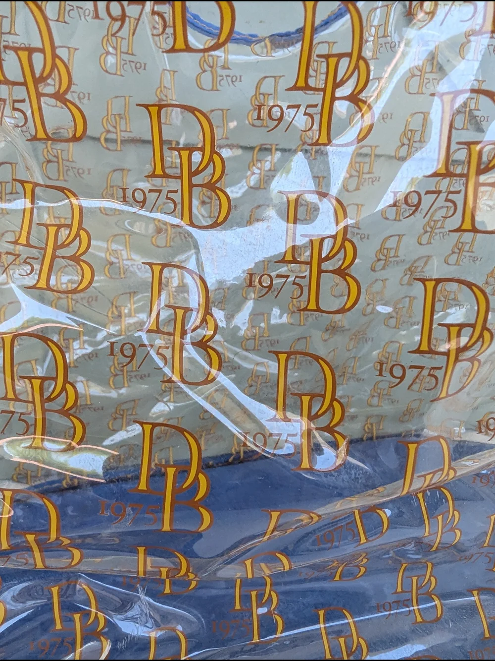 Dooney & Bourke Clear Tote with Blue Trim and Gold Logo Print